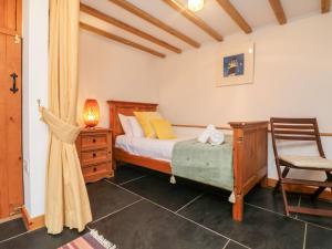 a bedroom with a bed and a desk and a chair at Hay Loft in Camborne