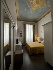 Hotel Genova Liberty في جينوا: غرفه فندقيه سريرين وسقف