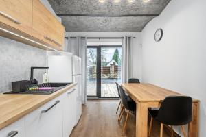 a kitchen with a wooden table and a dining room at Apartmán Hamrovka in Velké Hamry
