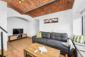 a living room with a couch and a tv at Apartmán Hamrovka in Velké Hamry