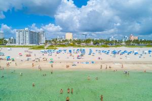 a group of people in the water at a beach at Bentley Hotel South Beach in Miami Beach