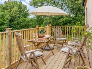 a wooden deck with a table and chairs and an umbrella at 2 bed in Barnstaple 87749 in Landkey