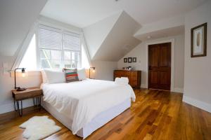 a bedroom with a white bed and a large window at Captivating Cowgirl in Denver