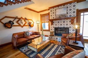 sala de estar con muebles de cuero y chimenea en Captivating Cowgirl en Denver