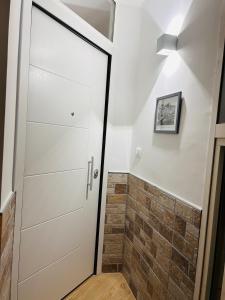 La salle de bains est pourvue d'une porte blanche et d'un mur en briques. dans l'établissement B&B Queen's Luck, à Ercolano