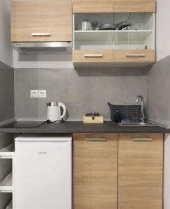 a kitchen with wooden cabinets and a white refrigerator at LA CASA DE PROFESOR 5 in Kalabaka