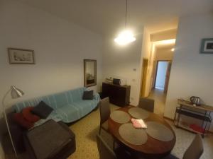 uma sala de estar com um sofá azul e uma mesa em Console Camprini Rooms & Apartments - Parco Tassinari em Faenza