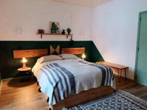 a bedroom with a large bed with a green headboard at Solo Azores Guesthouse in Nordeste