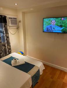 Zimmer mit 2 Betten und einem Flachbild-TV an der Wand in der Unterkunft RJ Travellers Inn in Catbalogan