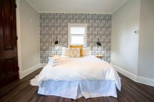 a bedroom with a white bed and a black and white patterned wall at The Charming Cowboy in Denver