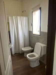 a white bathroom with a toilet and a sink at Casa Algarrobos in San Javier