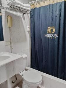 baño con aseo y cortina de ducha azul en HOTEL DORAL, en Guayaquil