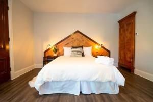 a bedroom with a large white bed with a wooden headboard at The Western Allure in Denver