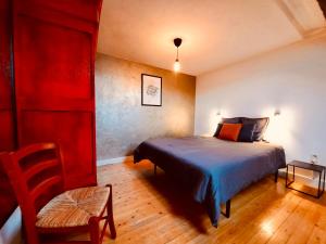 a bedroom with a bed and a chair in it at La Vieille Forge B&B in Houffalize
