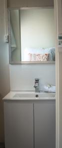 y baño con lavabo blanco y espejo. en Canonbar Motel en Nyngan