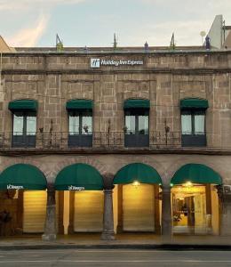 um edifício com toldos verdes ao lado em Holiday Inn Express Morelia Centro Historico em Morelia