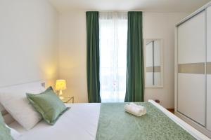 a bedroom with a large bed with green curtains at Apartment Karlo in Split