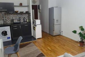 a kitchen with a refrigerator and a chair in a room at Paradise Studio in Pontault-Combault
