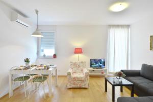 a living room with a white table and a couch at Apartment Karlo in Split