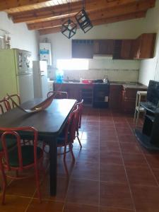 eine Küche mit einem Tisch und Stühlen sowie einem Kühlschrank in der Unterkunft rafaella in Villa Anizacate