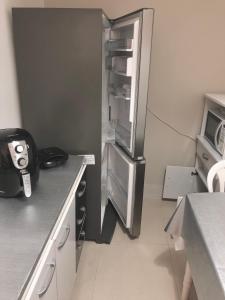 una cucina con frigorifero in acciaio inossidabile con porta aperta di Casa em Capao a Capão da Canoa