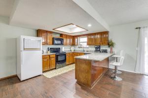 a kitchen with wooden cabinets and a white refrigerator at Rogers Vacation Home with Yard 5 Mi to Bentonville in Rogers