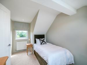 a bedroom with a white bed and a window at Ryseholme in Summer Bridge