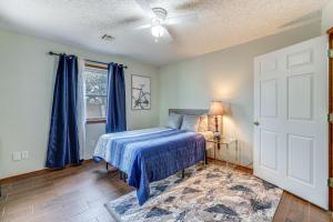 sypialnia z łóżkiem i oknem z niebieskimi zasłonami w obiekcie Rogers Vacation Home with Yard 5 Mi to Bentonville w mieście Rogers