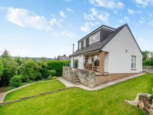 a white house with a black roof and a yard at Ryseholme in Summer Bridge