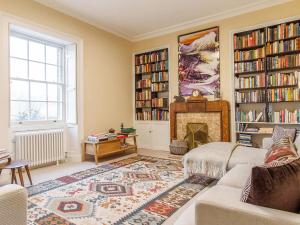 a living room with a fireplace and bookshelves at The Manse - Uk42249 in Broughton