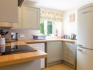a kitchen with white cabinets and a sink at Gargrave Cottage - Uk42248 in Broughton