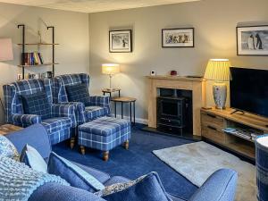 a living room with two couches and a television at Beach Croft in Brora