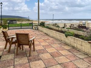 a patio with a table and two chairs and the beach at Beach Croft in Brora