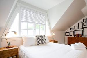 a bedroom with a white bed and a window at Smiths Crescendo in Denver
