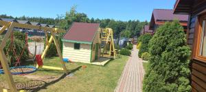 a playground with a house and a slide at Zielony Gaj in Wicie