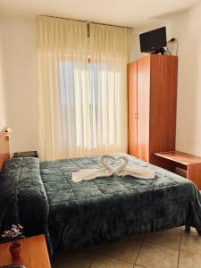 a hotel room with a bed with two towels on it at Hotel Vico Alto Siena in Siena