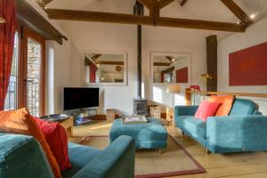 a living room with two blue couches and a tv at Mixit Cottage in Kingsbridge