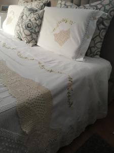 アヴェイロにあるQuinta das Águiasの白いベッド(金の刺繍枕付)