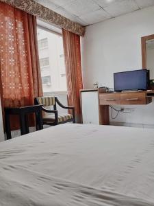 1 dormitorio con cama, escritorio y ordenador en HOTEL DORAL, en Guayaquil
