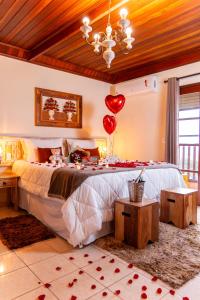 un dormitorio con una cama con un montón de globos en Pousada Cerejeiras, en Monte Verde