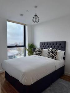 um quarto com uma cama grande e uma janela grande em Penthouse Flat in Manchester em Manchester