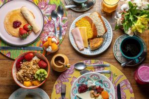 a wooden table with plates of food on it at Pousada Cerejeiras in Monte Verde