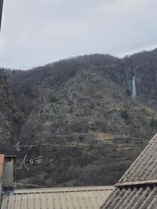 a view of a mountain with a waterfall on it at Maison Isola Village in Isola