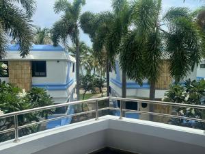 a balcony of a house with palm trees at บ้านนาวาภิรมย์B8/3 in Ban Khlong Khot