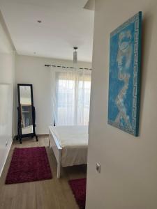 um quarto com uma cama e um quadro na parede em Luxury Apartement Near the Beach em Sidi Bouqnadel