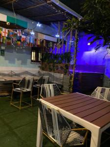 uma mesa e cadeiras num restaurante com iluminação roxa em Hostel la Antigua Capsula em Cartagena das Índias