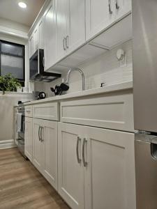 a kitchen with white cabinets and a sink at Brooklyn retreat 1 in Brooklyn