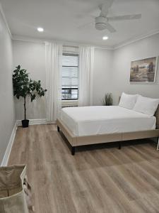 a white bedroom with a large bed and a window at Brooklyn retreat 1 in Brooklyn