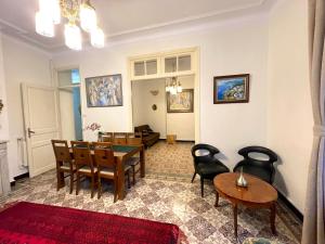 ein Wohnzimmer mit einem Esstisch und Stühlen in der Unterkunft Appartement Dans Immeuble Haussmanien in Alger