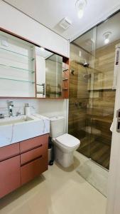 La salle de bains est pourvue de toilettes, d'un lavabo et d'une douche. dans l'établissement Lindo apartamento frente mar em condomínio club, à Florianópolis